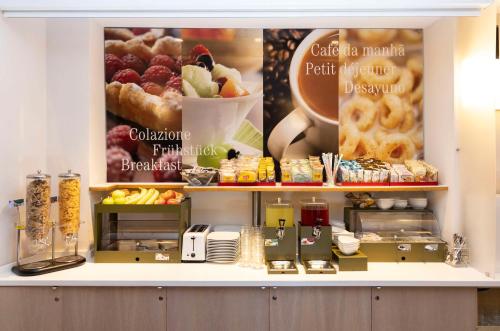 a bakery with a counter with pastries and food at Best Western Porto Antico in Genova