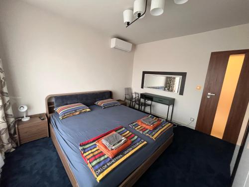 a bedroom with a bed with blue sheets and a mirror at Botabara 312 Self Catering Beach Apartment in Pomorie