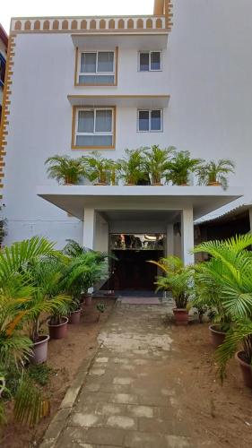 a white building with plants in front of it at Sridham 100 mts from Sea Beach in Puri