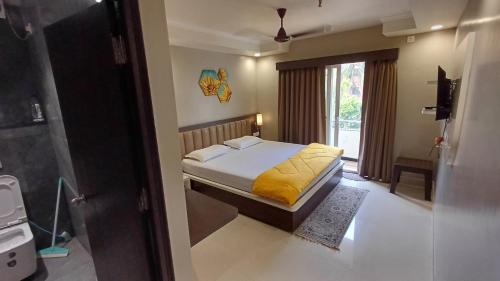 a bedroom with a bed with a yellow blanket at Sridham in Puri
