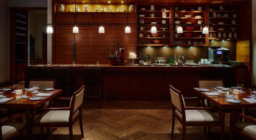 um restaurante com mesas de madeira e um bar em Park Hyatt Chennai em Chennai