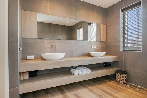łazienka z 2 umywalkami i lustrem w obiekcie Vakantiehuis - Albert Aylerstraat 10 - Middelburg w mieście Middelburg