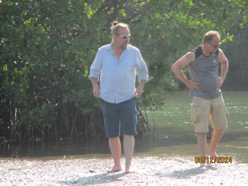 two men standing on the beach near the water at Ralph recedency in Kochchikade