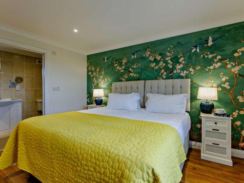 a bedroom with a large bed with a green wall at 2 Bed in Westward Ho 89868 in Westward Ho