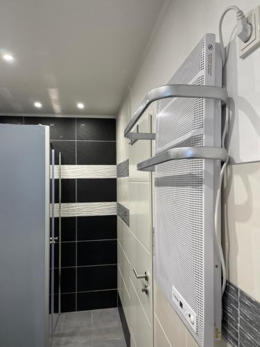 um chuveiro na casa de banho com azulejos pretos em Bina Familienapartment Trier em Trier