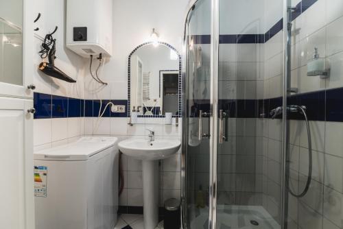 a white bathroom with a sink and a shower at Kawiory 2/22 in Kraków
