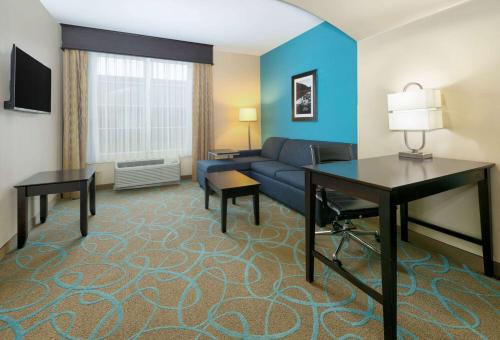 a living room with a couch and a table at La Quinta by Wyndham Clinton Historic Route 66 in Clinton