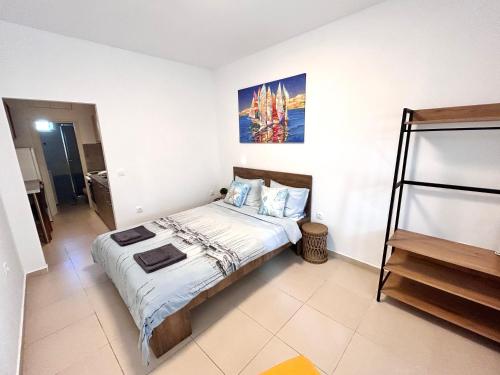 a bedroom with a bed and a painting on the wall at Peraia Studio in Perea