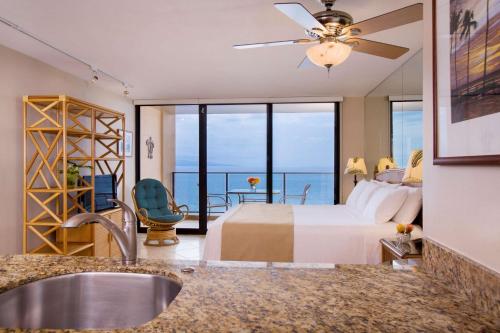 a bedroom with a bed and a view of the ocean at Aston Mahana at Kaanapali in Lahaina