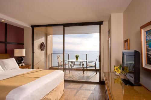 a hotel room with a bed and a view of the ocean at Aston Mahana at Kaanapali in Lahaina