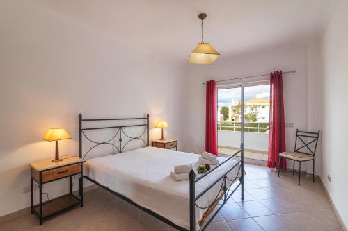 a bedroom with a bed and a large window at Aldeamento Turistico Aldeia da Galé in Albufeira