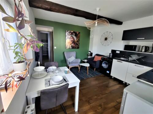 een woonkamer met een witte tafel en stoelen bij Appartement T2 "JUNGLE" Centre Ville de VITRÉ au calme coté cour in Vitré
