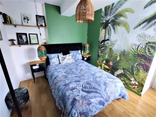 una camera con letto e piumone blu di Appartement T2 "JUNGLE" Centre Ville de VITRÉ au calme coté cour a Vitré