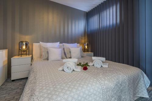 Un dormitorio con una cama grande con toallas. en Panoramaussicht und Whirlpool im exklusiven Viertel, en Crikvenica