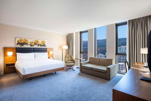 a hotel room with a bed and a chair at Hilton Garden Inn Tbilisi Chavchavadze in Tbilisi City
