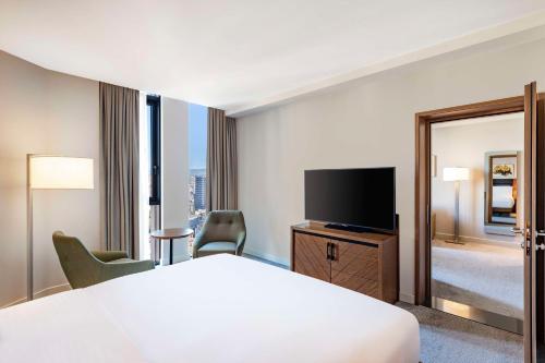 a hotel room with a bed and a flat screen tv at Hilton Garden Inn Tbilisi Chavchavadze in Tbilisi City