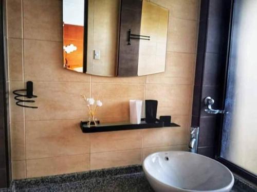 a bathroom with a sink and a mirror at Seaheart Guesthouse in Dauis