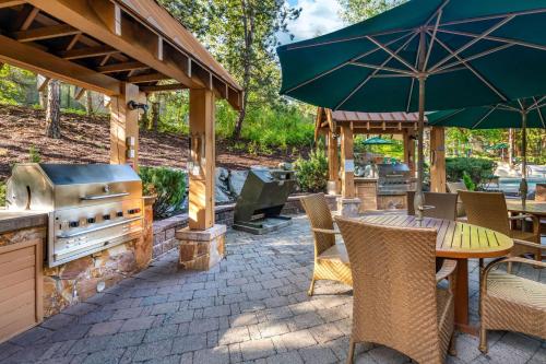an outdoor patio with a grill and a table and chairs at Hilton Grand Vacations Club Whistler in Whistler