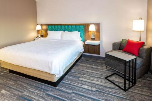 a hotel room with a bed and a chair at Hampton Inn Selma, Ca in Selma