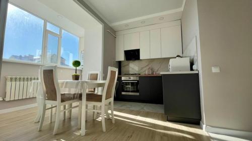 a kitchen with a table and chairs in a room at 1-комнатные апартаменты ЖК "Саулет Курылыс" in Aktobe