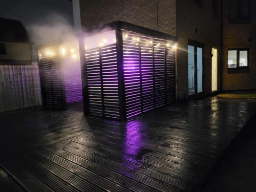 a room with purple lights on the side of a building at Birmingham Airport Luxury3BRHOME in Marston Green