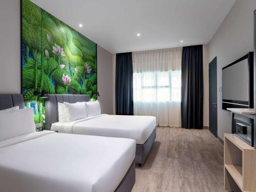 um quarto de hotel com duas camas e uma televisão em ibis Styles Sepang KLIA em Sepang