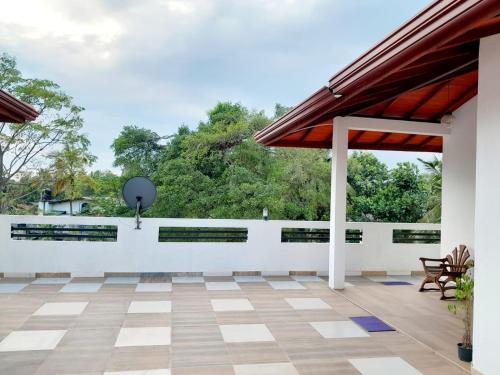 an outdoor patio with a white wall and a table at Unic Residence And Transit Hotel in Katunayake