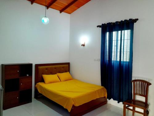 a bedroom with a bed and a chair and a window at Unic Residence And Transit Hotel in Katunayake