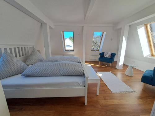 a bedroom with a bed and a blue chair at Penthouse über den Dächern Badenweilers in Badenweiler