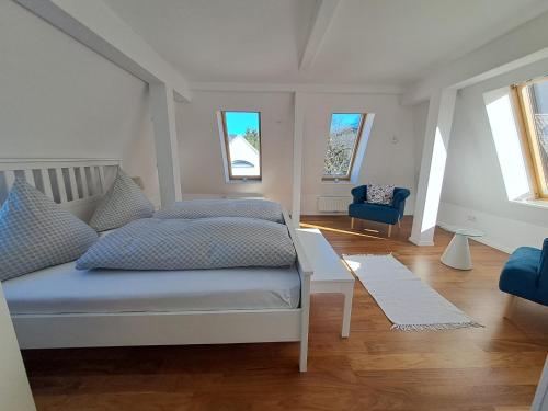ein Schlafzimmer mit einem Bett und einem blauen Stuhl in der Unterkunft Penthouse über den Dächern Badenweilers in Badenweiler