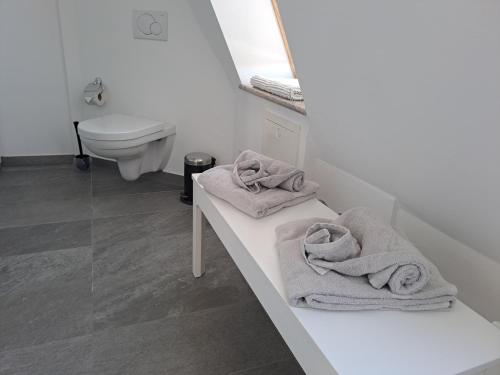 a white bathroom with towels on a counter at Penthouse über den Dächern Badenweilers in Badenweiler