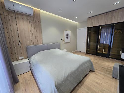 - une chambre avec un grand lit blanc et des placards en bois dans l'établissement Ultra comfort apartment in NRG Oybek, à Yakkasaray