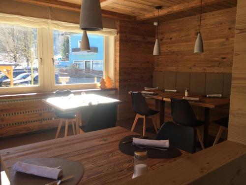 a dining room with wooden walls and a table and chairs at Fedaia Joy B&B in Canazei