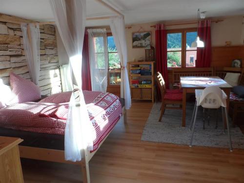 a bedroom with a bed and a table and chairs at Alpakahof Wechs in Bad Hindelang
