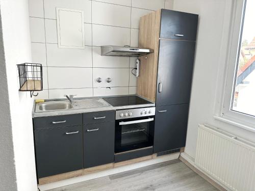 eine Küche mit einem schwarzen Kühlschrank und einer Spüle in der Unterkunft Double Room in the black Forest in Villingen-Schwenningen