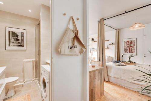 une chambre blanche avec un lit et un miroir dans l'établissement Marini - Studio à Auteuil, à Paris