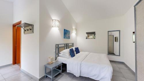 1 dormitorio con 1 cama con sábanas blancas y espejo en Poisson Rouge, en Bonifacio