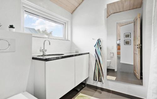 La salle de bains blanche est pourvue d'un lavabo et d'une fenêtre. dans l'établissement Cozy Home In Odder With Wifi, à Odder