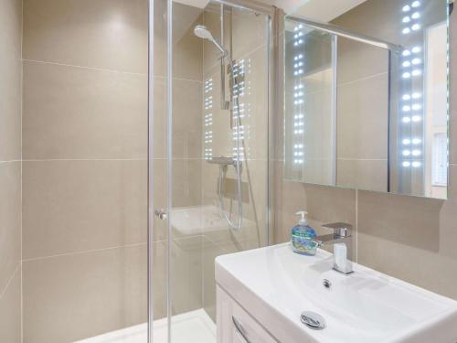 a white bathroom with a shower and a sink at 2 Bed in Cartmel 86829 in Cark