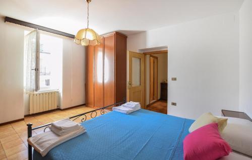 um quarto com uma cama azul e uma grande janela em 2 Bedroom Lovely Apartment In Bagolino, F, P,caffaro em Ponte Caffaro