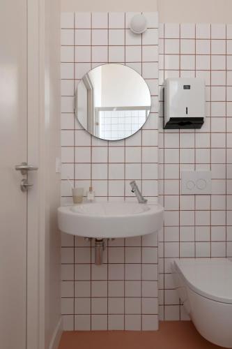 a bathroom with a sink and a mirror on the wall at SLO Hostel Nice in Nice