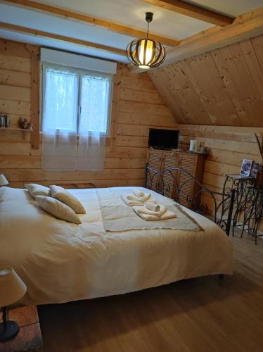 ein Schlafzimmer mit einem großen weißen Bett in einem Zimmer in der Unterkunft Le chalet des 4 saisons in Mers-sur-Indre