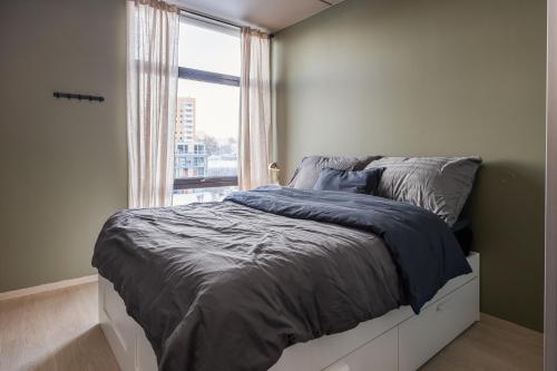 een slaapkamer met een groot bed en een raam bij Mellomila 69 in Trondheim