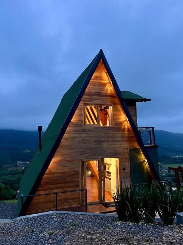 a wooden house with a green roof at CHALÉ MALACARA VIEW in Praia Grande