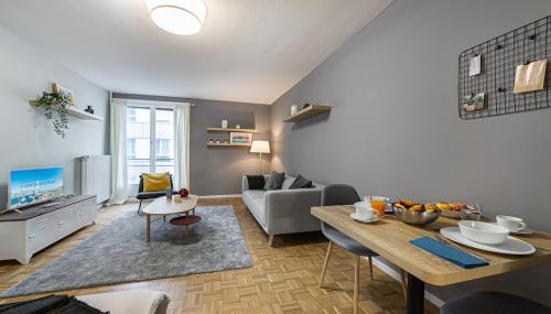 uma sala de estar com um sofá e uma mesa num quarto em Richemont Residence by Homenhancement em Genebra
