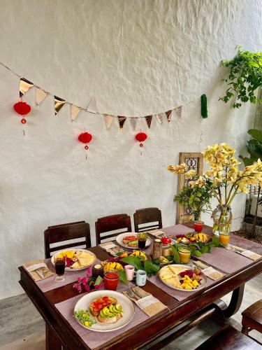 a wooden table with plates of food on it at Pao Homes - An Bang Beach Stone Villa in An Bang