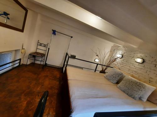 a bedroom with a large white bed and a brick wall at Authentic Belgrade Centre - Split level loft with patio in courtyard in Belgrade