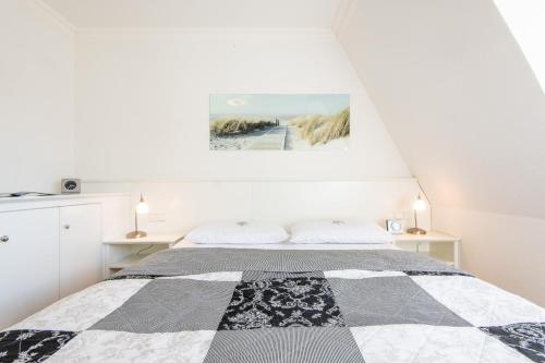 Dormitorio blanco con cama con edredón blanco y negro en Haus Maybachstraße, en Westerland