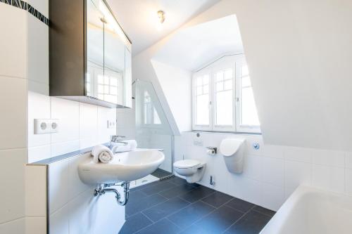 Un baño blanco con lavabo e inodoro. en Haus Maybachstraße, en Westerland