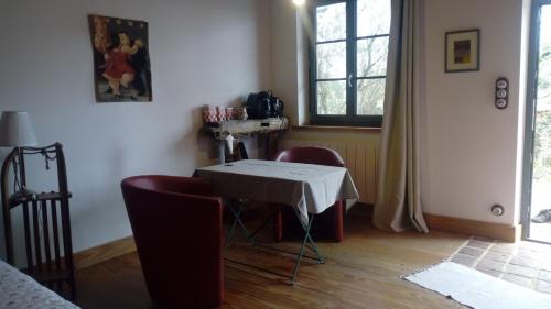 Zimmer mit einem Tisch, Stühlen und einem Fenster in der Unterkunft Chezlesgoyp in Cosges